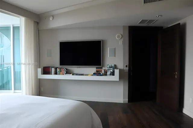 a bedroom with a bed and a view of kitchen