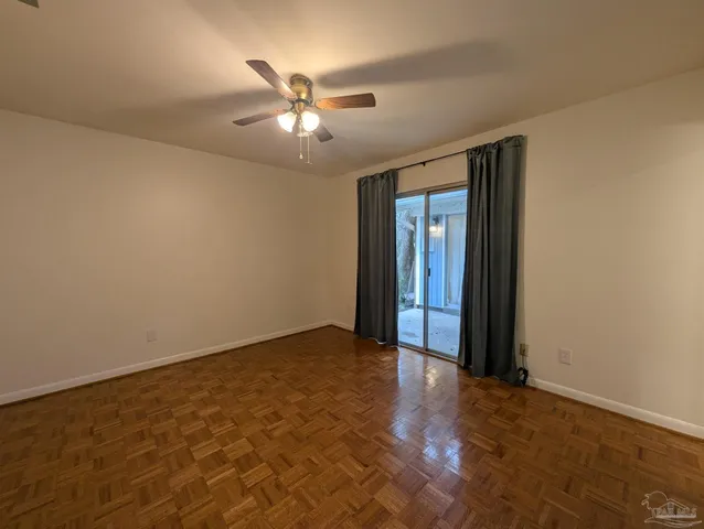 an empty room with a chandelier fan