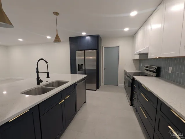a kitchen with kitchen island granite countertop a sink and stainless steel appliances