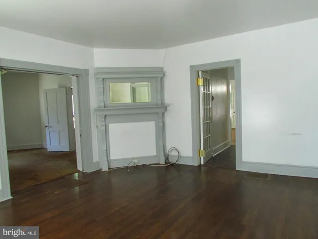 an empty room with wooden floor & closet area