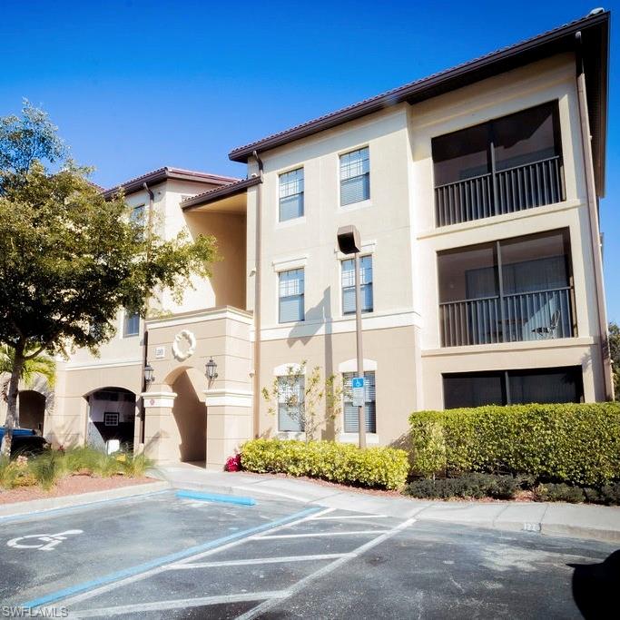 12975 Positano Circle, Unit 207 Naples, FL 34105 - Photo 15 of 24 View of building exterior featuring uncovered parking