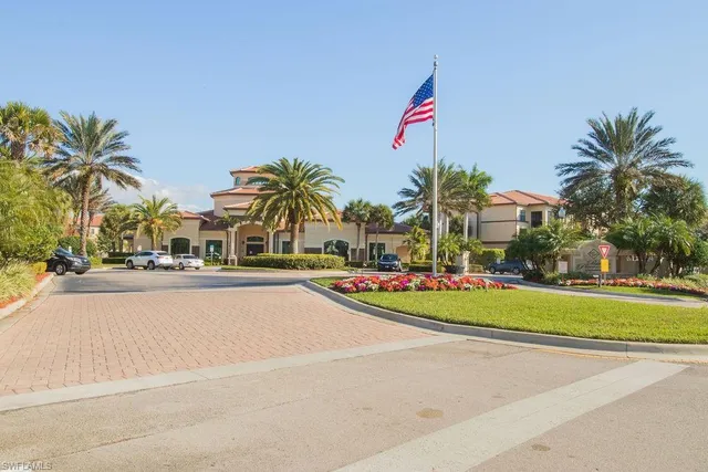 a front view of a house with a yard and palm trees