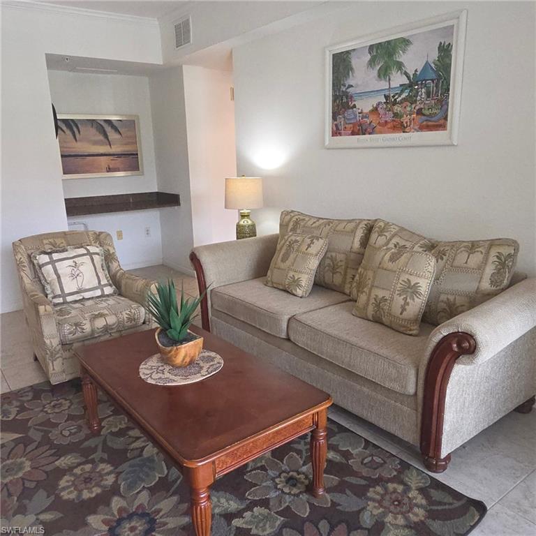 12975 Positano Circle, Unit 207 Naples, FL 34105 - Photo 5 of 24 Living room with tile patterned flooring and crown molding