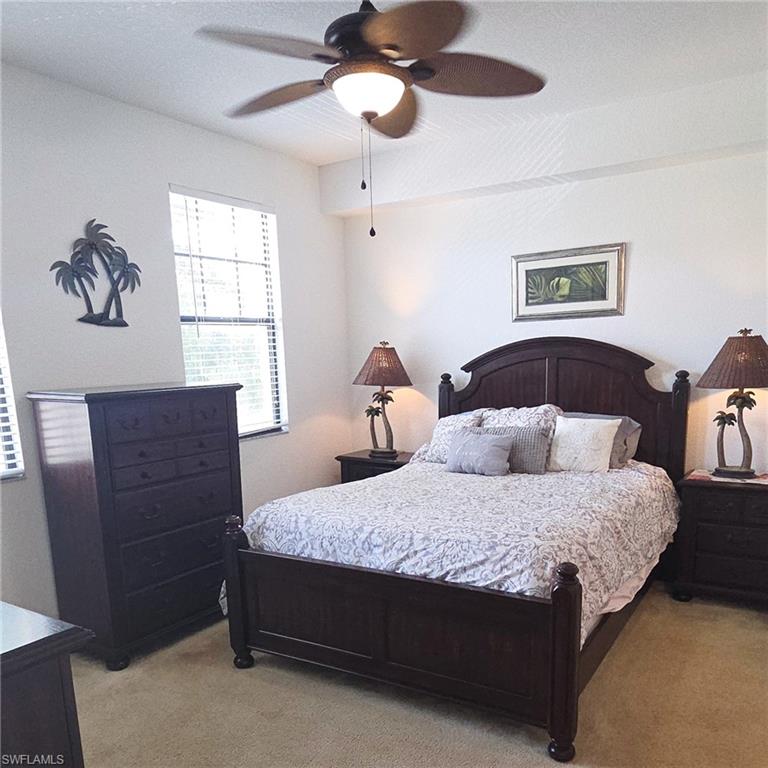 12975 Positano Circle, Unit 207 Naples, FL 34105 - Photo 7 of 24 Bedroom with carpet flooring and a ceiling fan