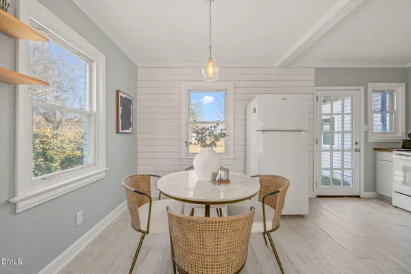 a dining room with furniture a chandelier and wooden floor