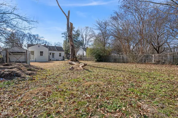 a view of a yard with wooden fence