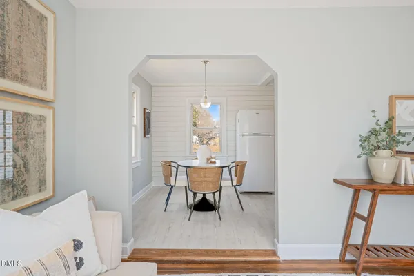 an empty room with wooden floor fireplace and windows