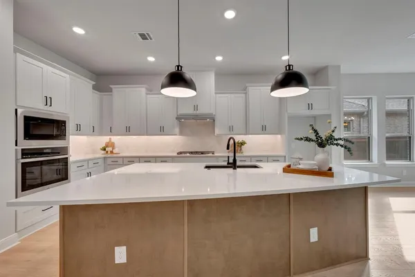a kitchen with kitchen island a counter space a sink and appliances