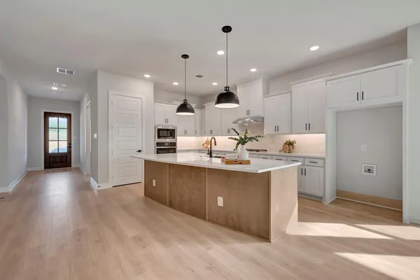 a large kitchen with stainless steel appliances lots of counter space sink and cabinets