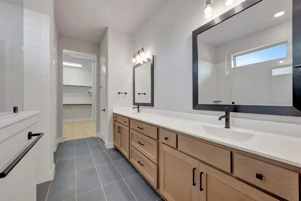 a bathroom with a double vanity sink a mirror and a shower