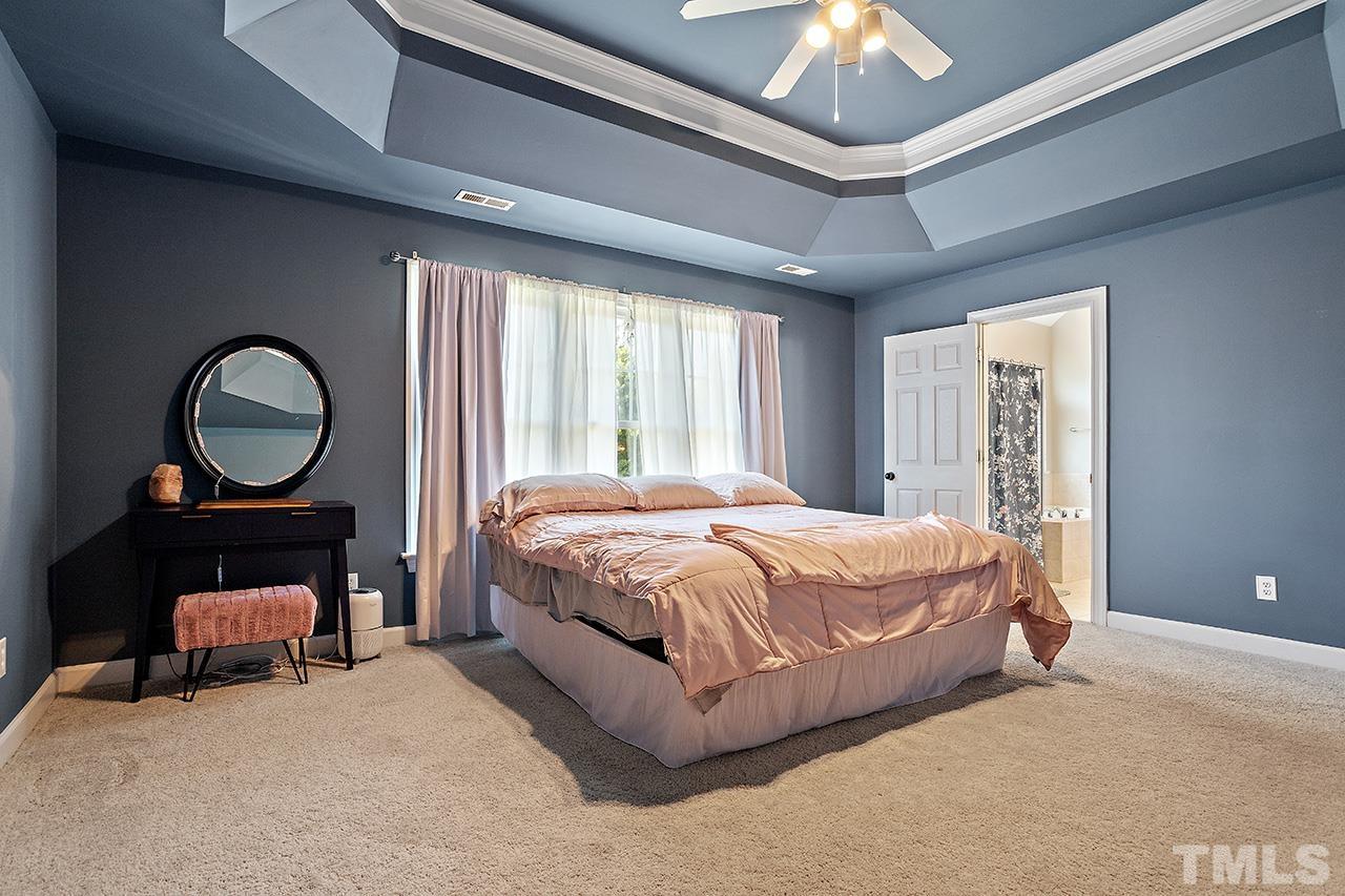 709 Rushing Falls Place Fuquay-Varina, NC 27526 - Photo 15 of 28 a bed room with a bed and a chandelier