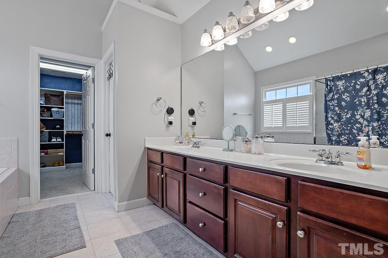709 Rushing Falls Place Fuquay-Varina, NC 27526 - Photo 16 of 28 a bathroom with double vanity sinks a vanity a lamp and a mirror