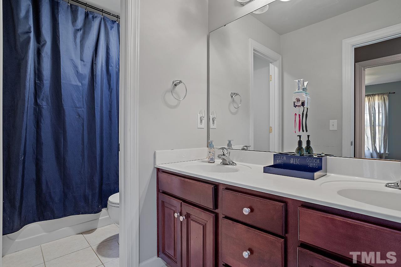 709 Rushing Falls Place Fuquay-Varina, NC 27526 - Photo 20 of 28 a bathroom with a double vanity sink and a mirror