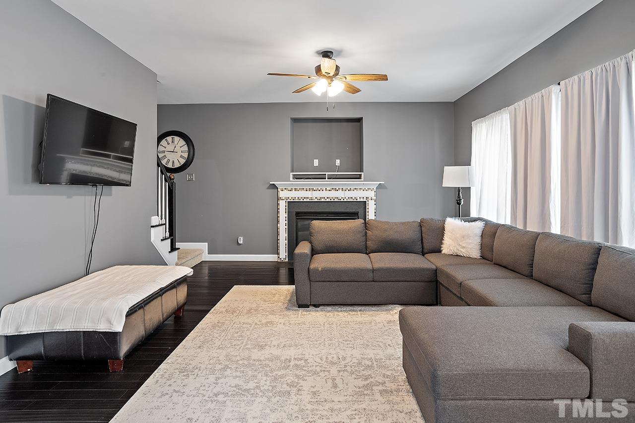 709 Rushing Falls Place Fuquay-Varina, NC 27526 - Photo 7 of 28 a living room with a couch a flat screen tv and gym equipment