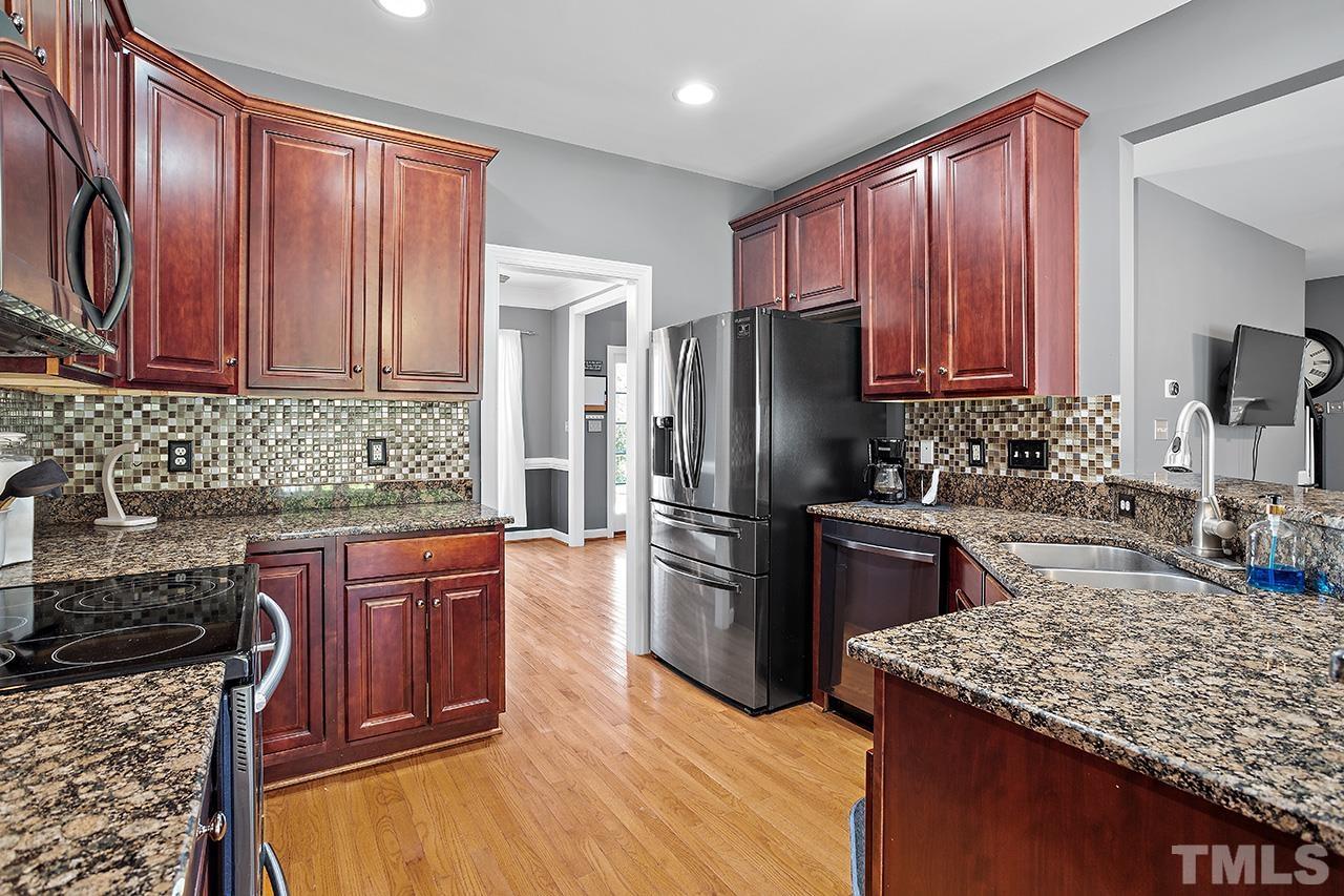 709 Rushing Falls Place Fuquay-Varina, NC 27526 - Photo 8 of 28 a kitchen with stainless steel appliances granite countertop a stove refrigerator sink and cabinets