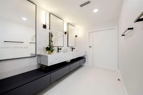 a bathroom with a double vanity sink a mirror and a shower