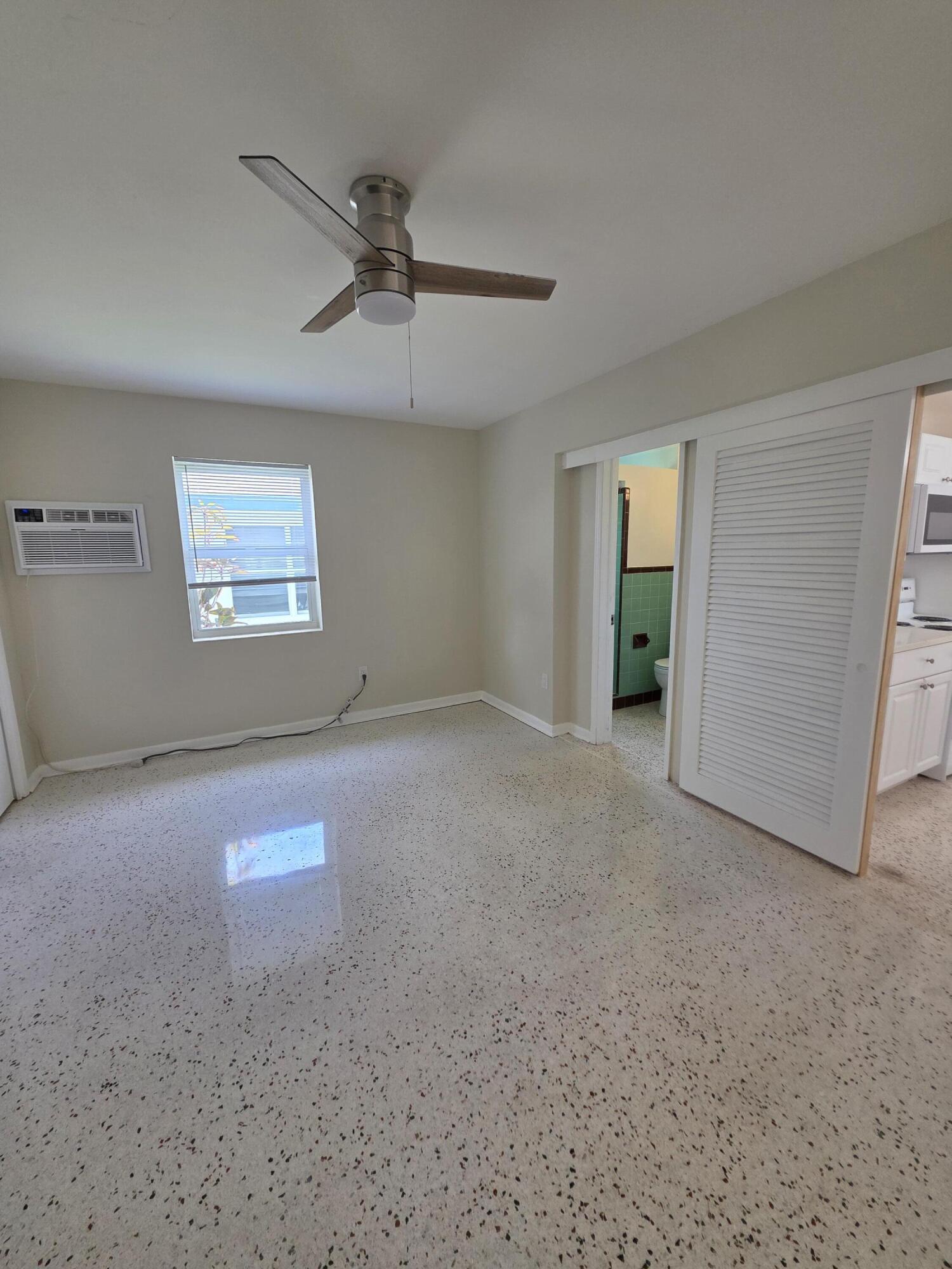 1216 Cabana Road, Unit 4 Singer Island, FL 33404 - Photo 5 of 10 an empty room with windows and ceiling fan