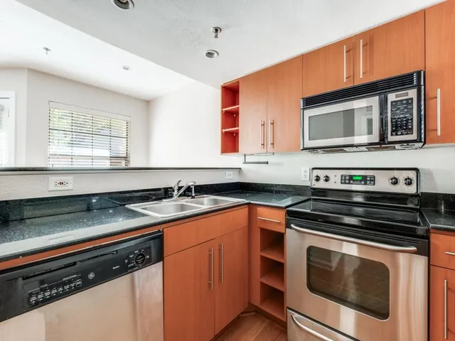 a kitchen with stainless steel appliances a stove sink and microwave