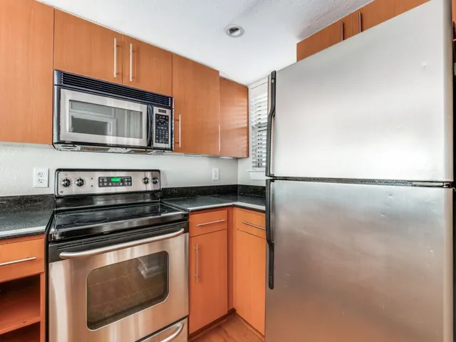a kitchen with stainless steel appliances granite countertop a stove microwave and sink