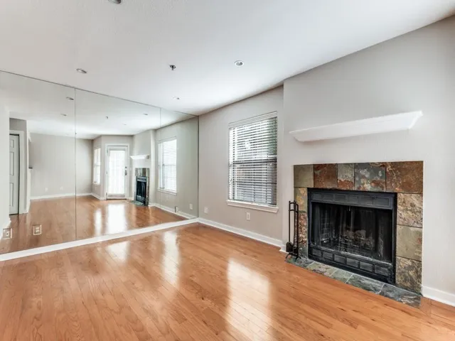 a view of an empty room with a fireplace and a window