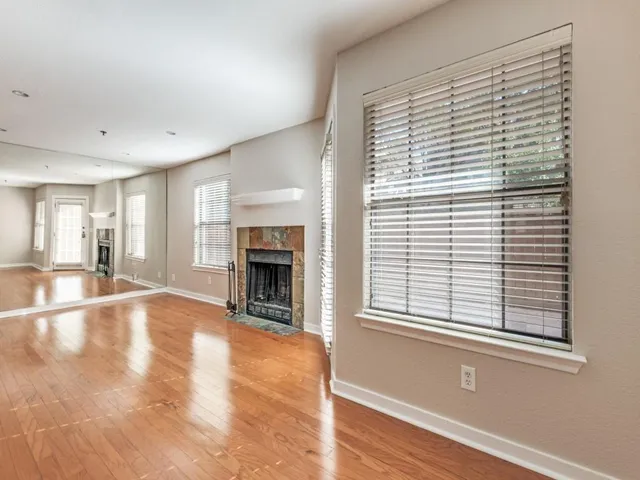 a view of an empty room with window and fire place