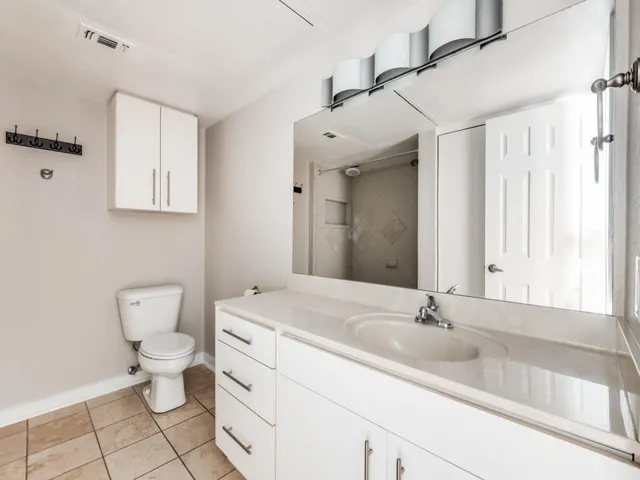 a bathroom with a sink a toilet and a mirror