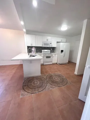 a view of kitchen with microwave and cabinets