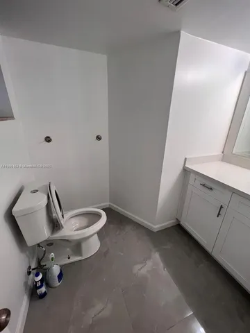a bathroom with a granite countertop toilet a sink and bathtub