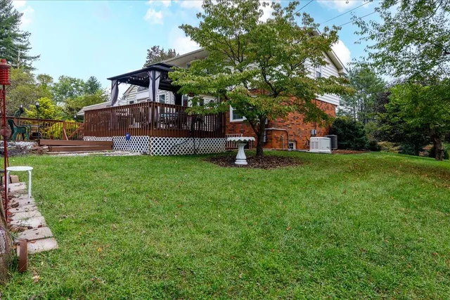 a view of a house with a big yard and large trees