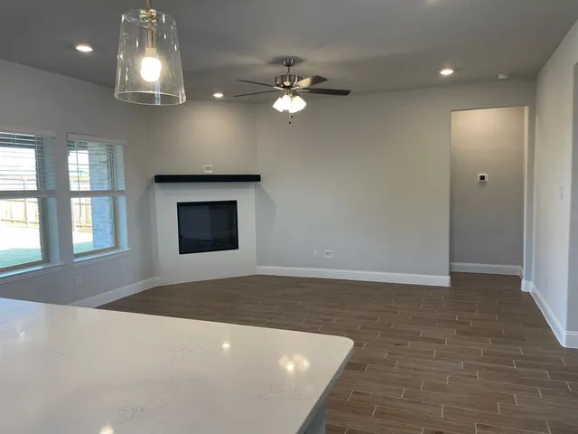 a view of a livingroom with a ceiling fan window and fire place