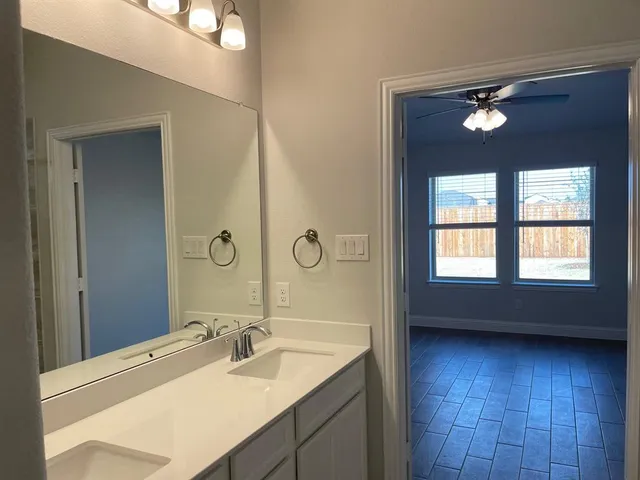 a bathroom with a double vanity sink a mirror and a bathtub