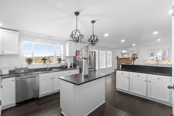 a kitchen with white cabinets and chandelier