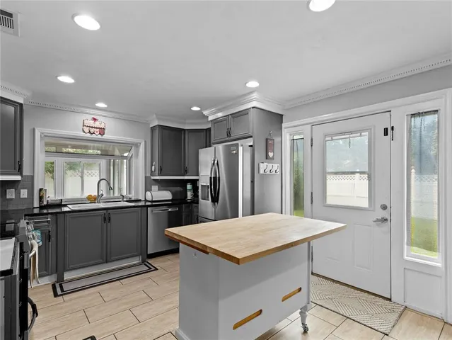 a kitchen with granite countertop a refrigerator and a sink