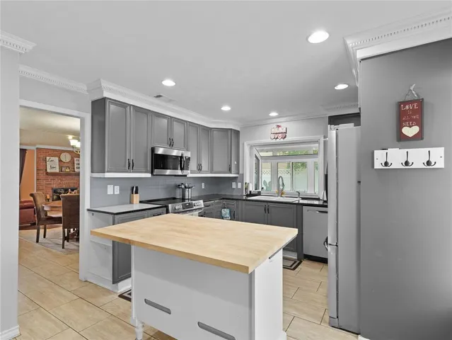 a large kitchen with a large counter top appliances and cabinets