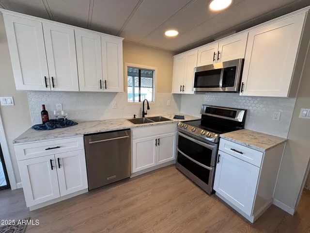 a kitchen with stainless steel appliances granite countertop a stove a sink and a microwave