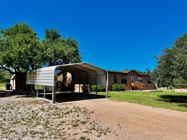 a front view of a house with a yard and trees