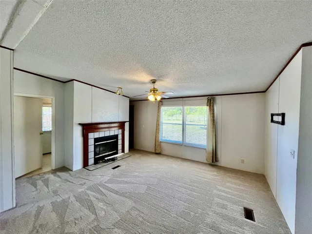 an empty room with fireplace chandelier and windows