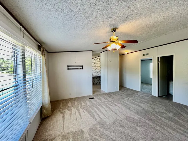 a view of a livingroom with a ceiling fan and window