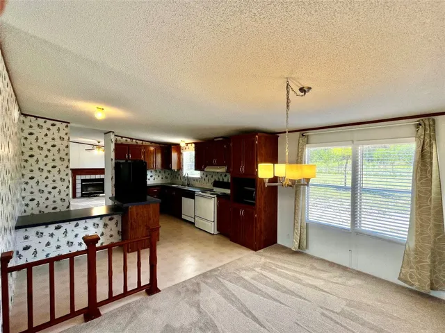 a kitchen with stainless steel appliances kitchen island granite countertop a table chairs in it and a wooden floor