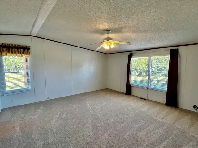 an empty room with a window and chandelier