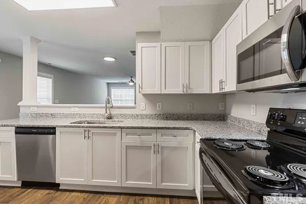 a kitchen with granite countertop a stove sink and cabinets