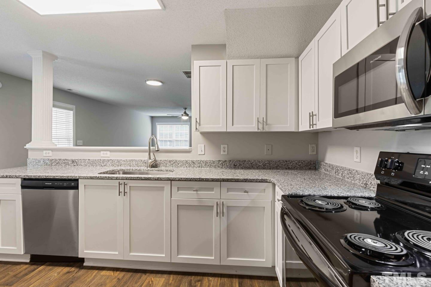 2101 Blackwolf Run Lane, Unit 5609 Raleigh, NC 27604 - Photo 6 of 19 a kitchen with granite countertop a stove sink and cabinets