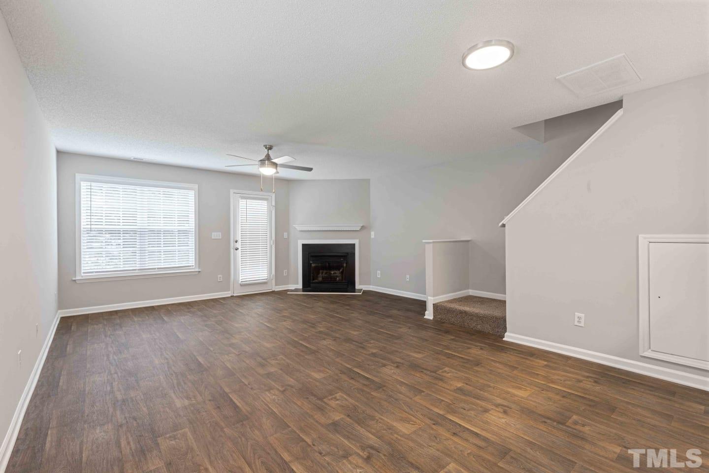 2101 Blackwolf Run Lane, Unit 5609 Raleigh, NC 27604 - Photo 7 of 19 an empty room with wooden floor fireplace and windows