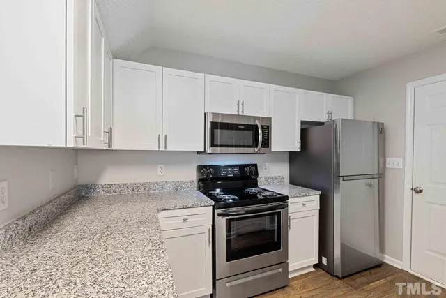 a kitchen with white cabinets and stainless steel appliances