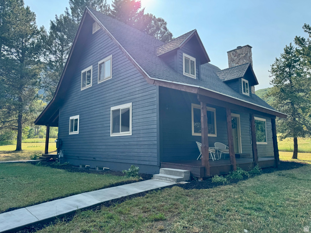 2807 North Ogden Canyon Road Eden, UT 84310 - Photo 70 of 72 A-frame style residence featuring dark blue siding, a covered porch with natural wood posts, and a prominent stone chimney