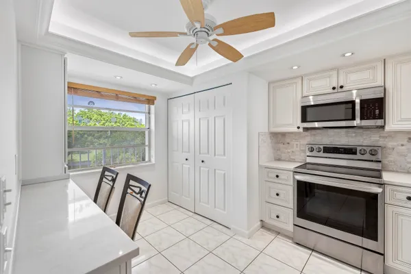 a kitchen with white cabinets and stainless steel appliances