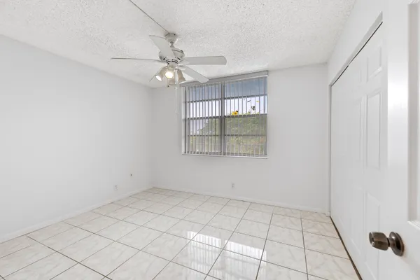 an empty room with chandelier fan
