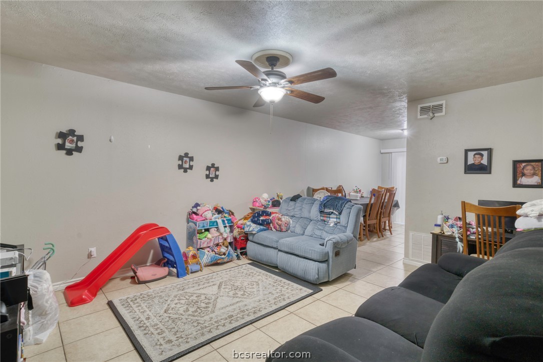 1908 Barak Lane, Unit 14 Bryan, TX 77802 - Photo 3 of 10 Tiled living room with ceiling fan and a textured ceiling