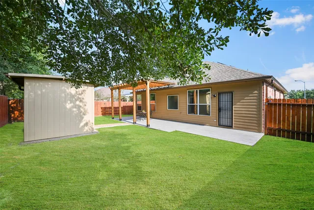 a view of a house with backyard and a tree