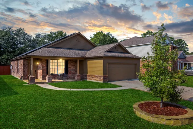 a front view of a house with a garden and trees